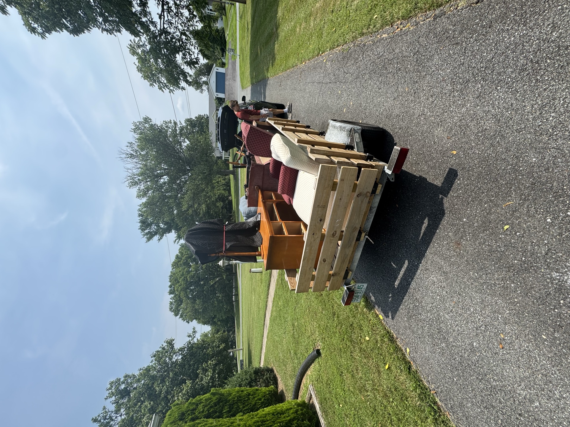 Trailer loaded with wood dressers and chairs from a furniture removal job