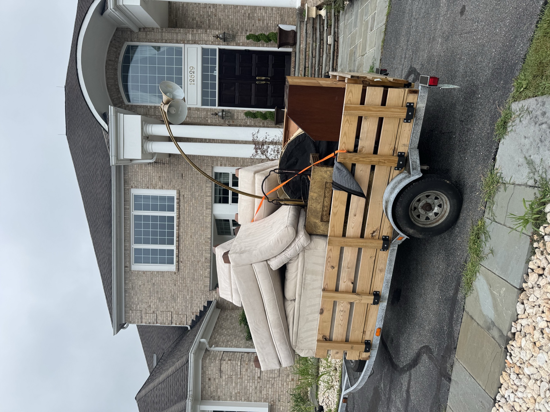 Trailer loaded with wood furniture and chairs for haul away