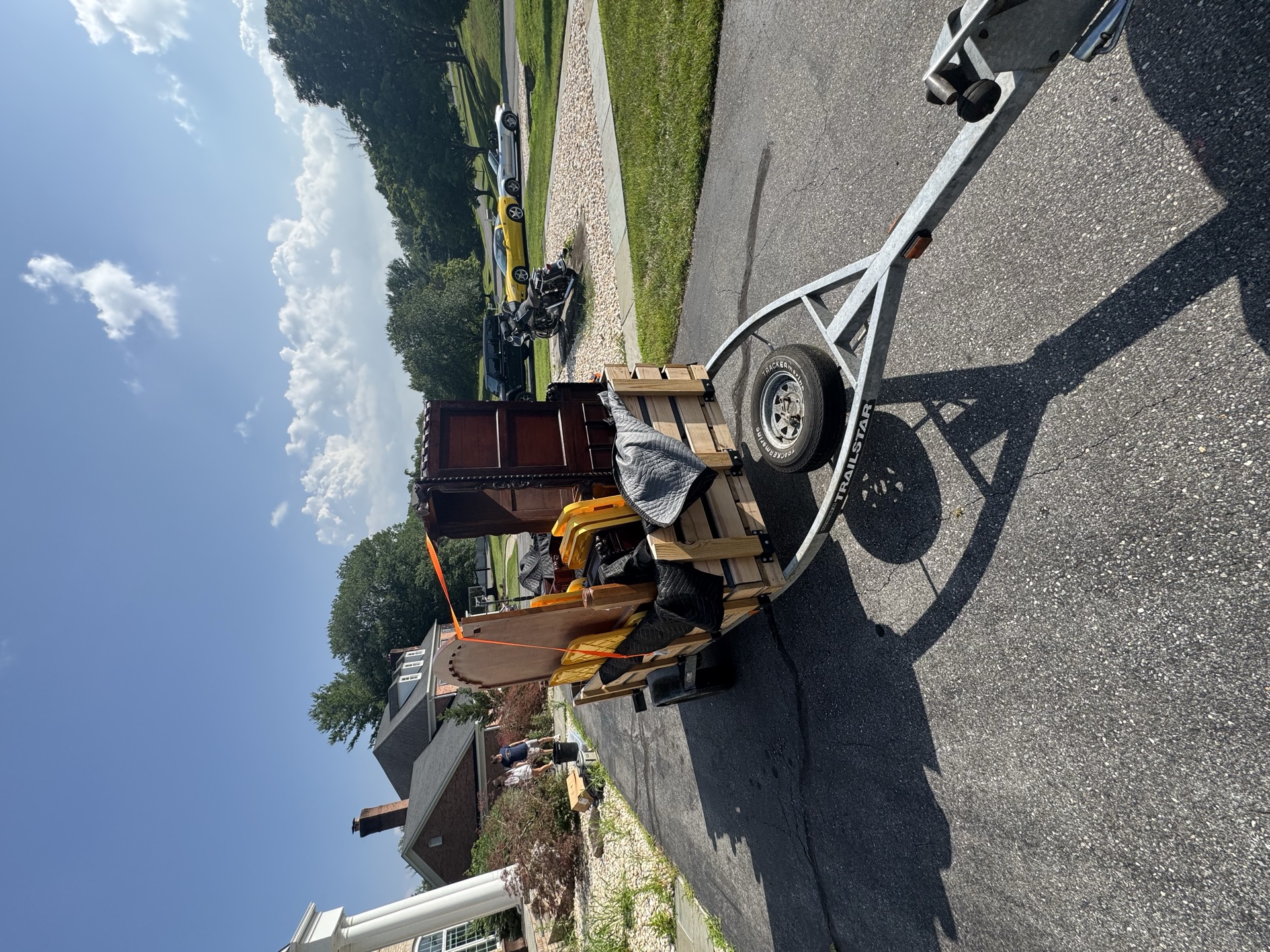 Trailer loaded with bagged debris and equipment on a residential street